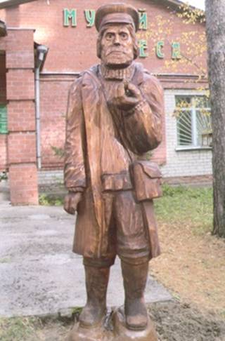 Скульптура деревянного мужика на входе Томского музея леса
